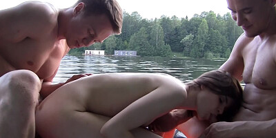 A cute brunette is on a boat, getting rammed with two cocks